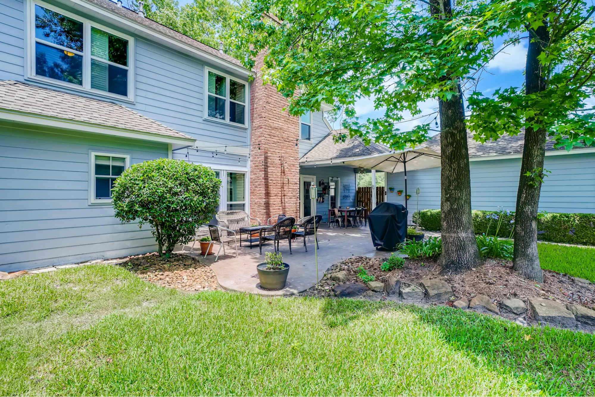This image depicts a blue house with an outdoor patio for relaxation and entertaining.