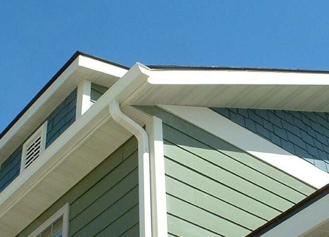 White aluminum soffit paneling from Rollex installed beneath the roofline of an olive green home