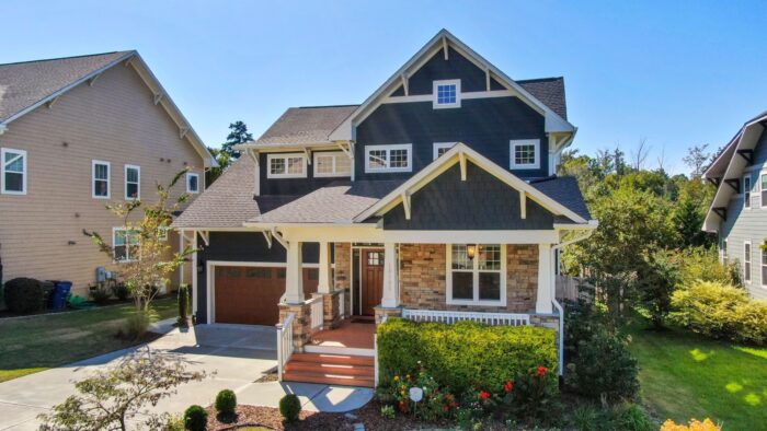 A modern craftsman house with a spacious porch and manicured lawn