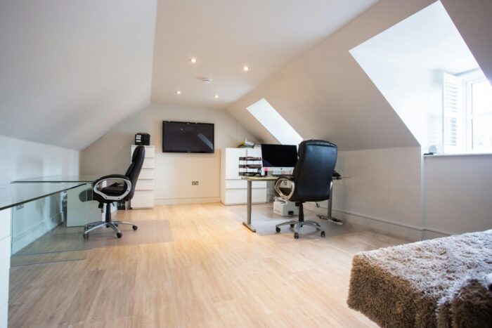 This converted attic creates an office space with desks and organization areas.