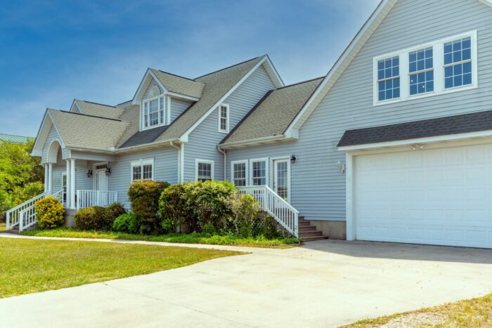 A charming multi-story home has blue horizontal vinyl siding.
