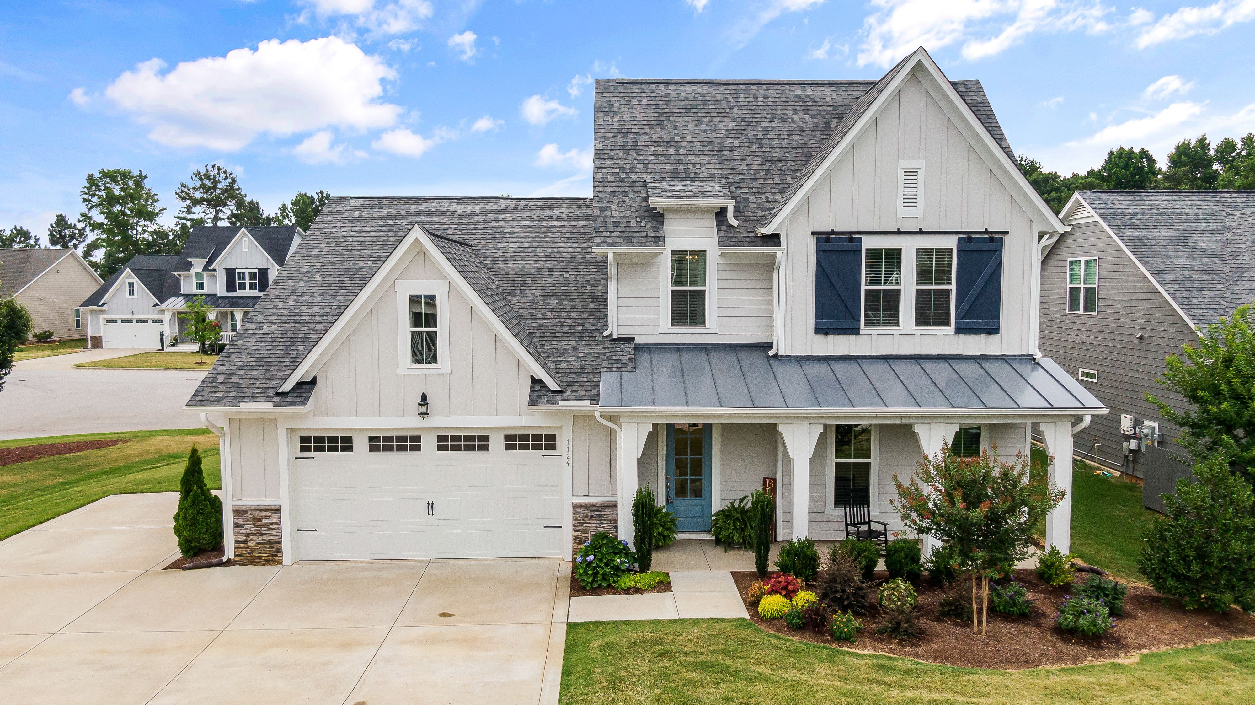 A home mixes vertical and horizontal siding and has white trim