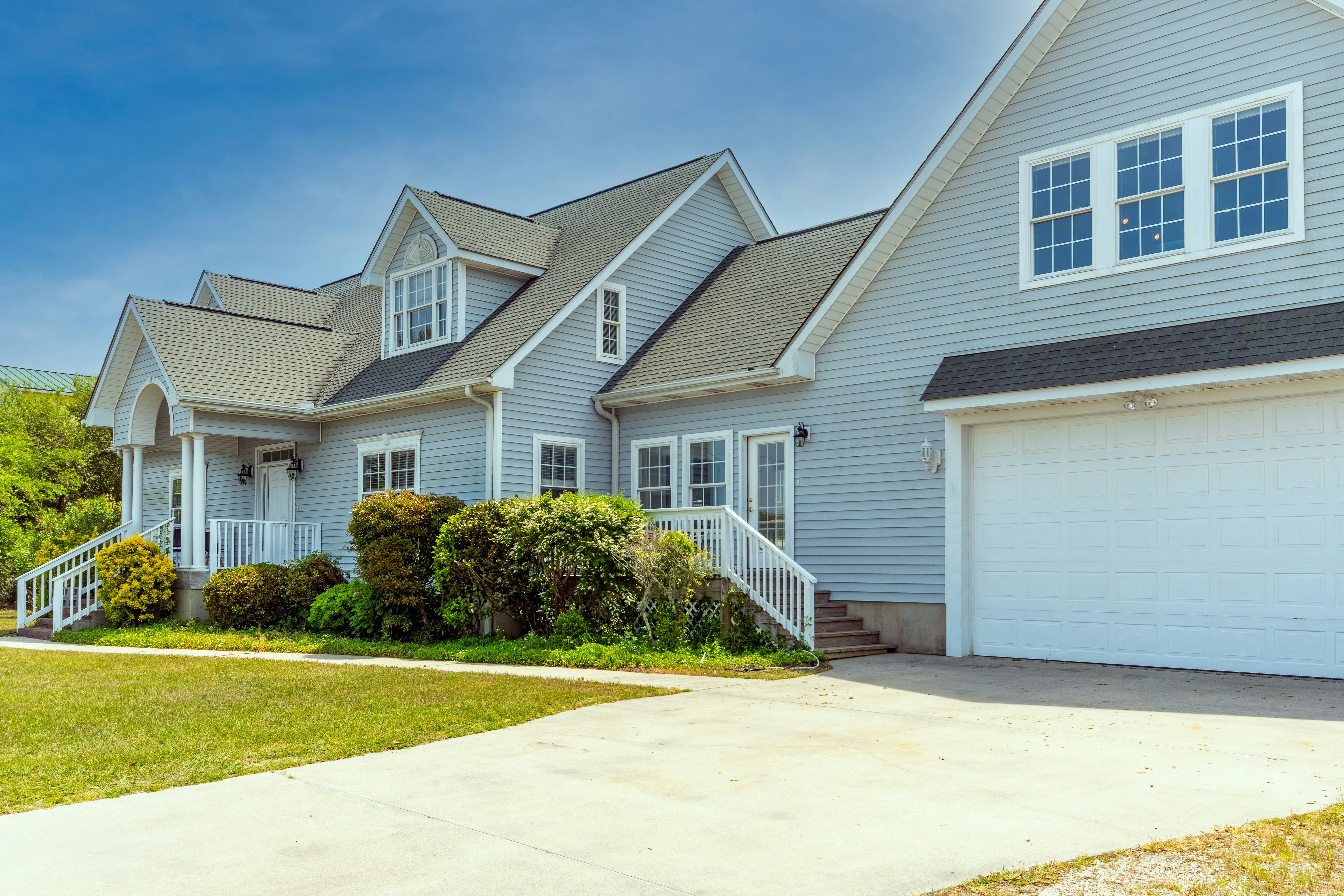 A charming multi-story home has blue horizontal vinyl siding.